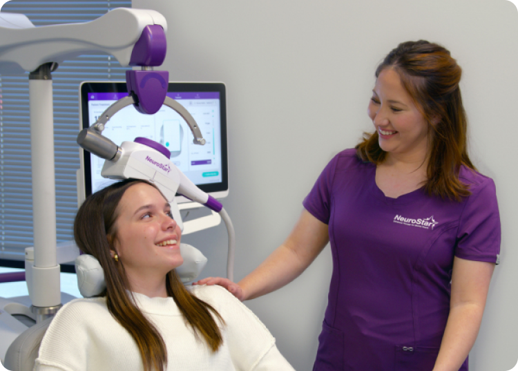 TMS specialist smiling towards patient while the patient is sitting calmly on TMS Chair